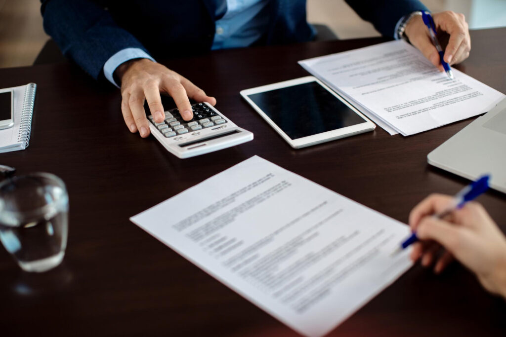 Closeup financial consultant going through paperwork meeting with client
